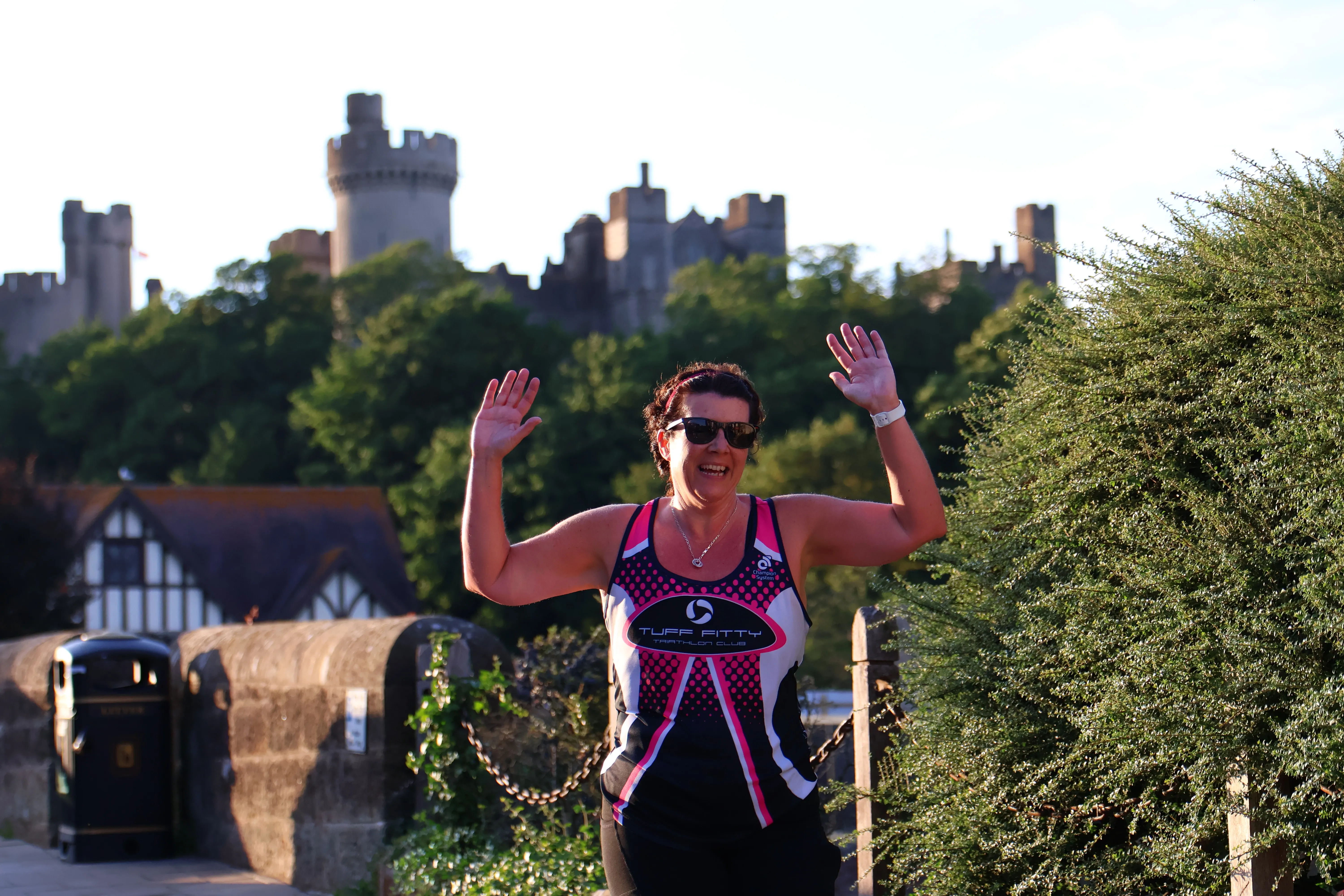 Athlete celebrating at the finish line with Arundel Castle in the background